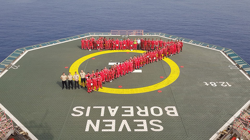 Seven Borealis offshore construction vessel crew on helideck forming shape of the number 7